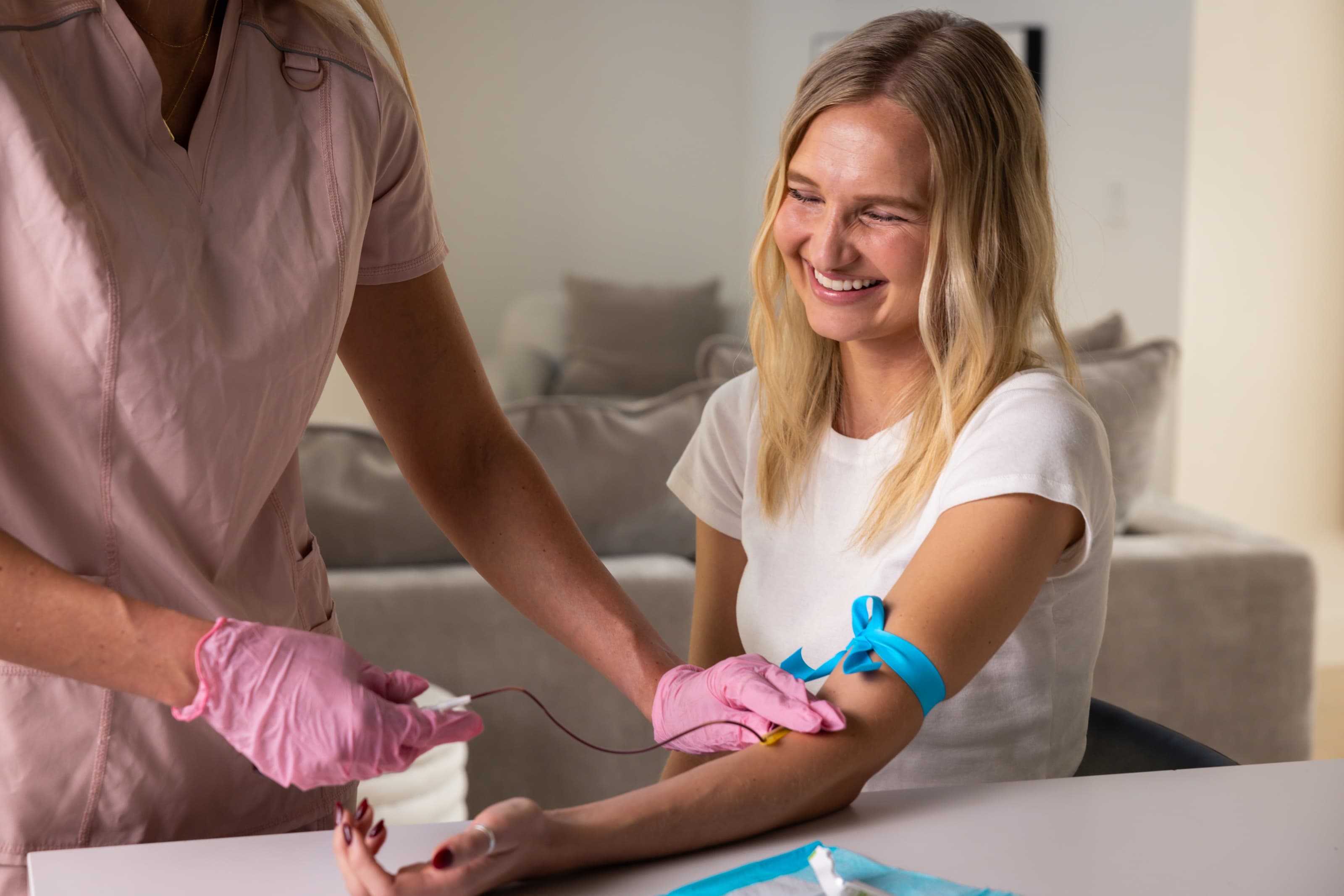 A nurse drawing blood at a patient's kitchen table